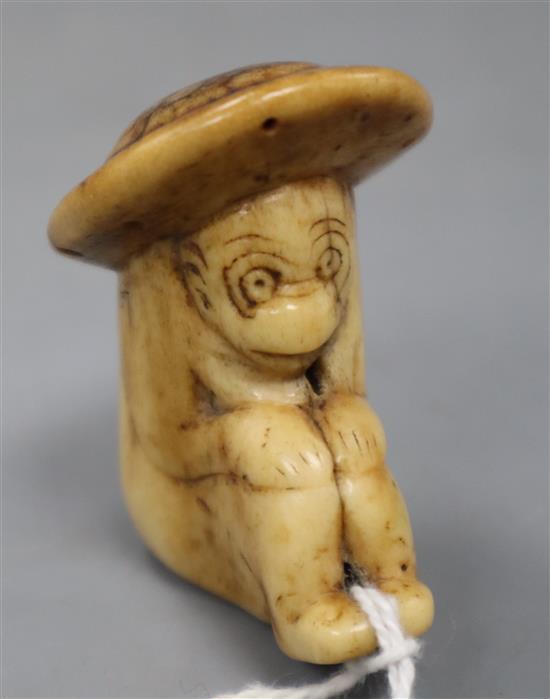 An 18th century Japanese stag horn netsuke of a monkey wearing a broad rimmed hat, depth 4cm height 4.75cm